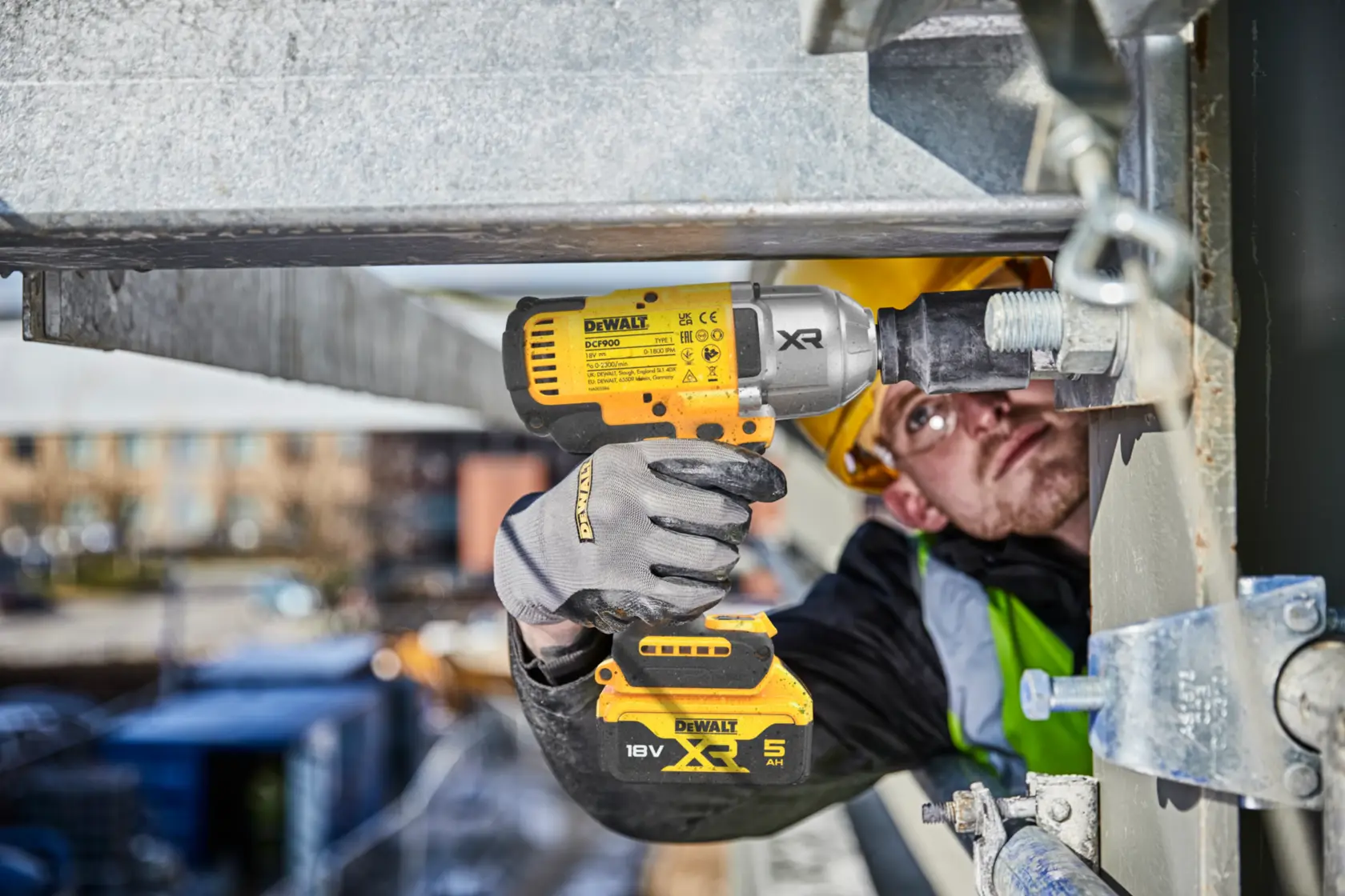 DEWALT DCF900NT-XJ, DCF900NT impact wrench in use on site. Construction worker tightens bolt with tool.
