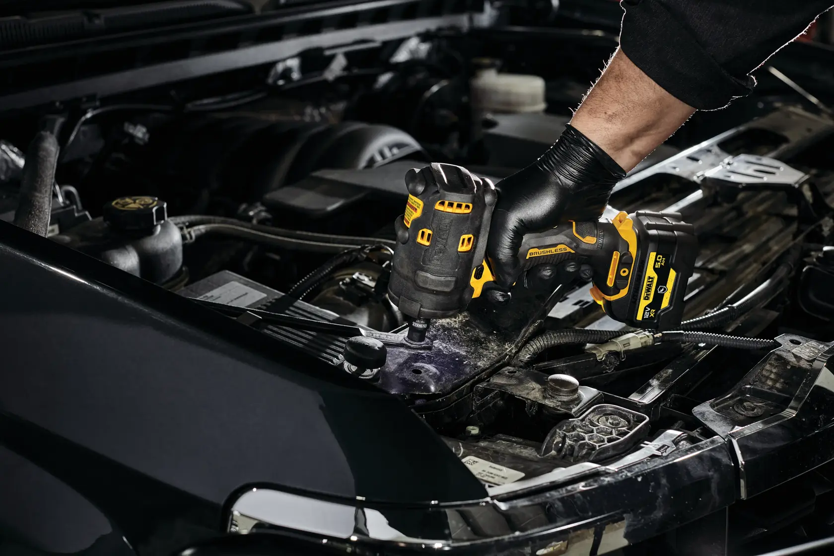 DEWALT DCF901P1G-QW, DCF901P1G impact driver used on car engine. Photography product category.