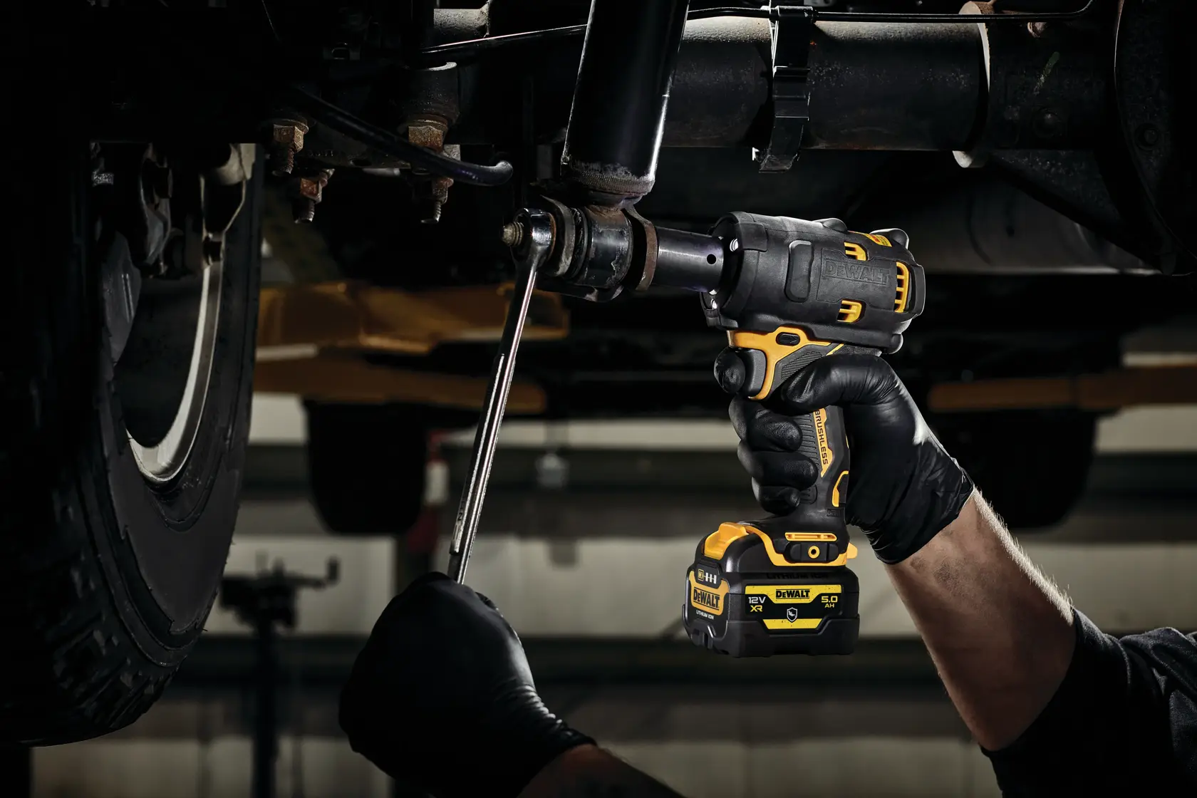 DEWALT DCF901P1G-QW, DCF901P1G impact wrench used under vehicle. Photography product for automotive work.