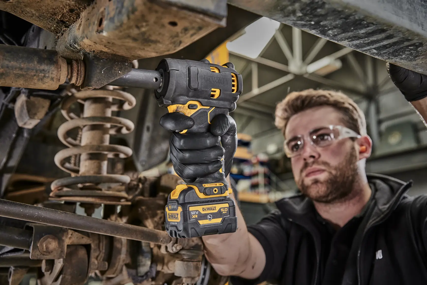 DEWALT DCF901P1G-QW, DCF901P1G impact wrench used in automotive work. Product visible in mechanic’s hand.