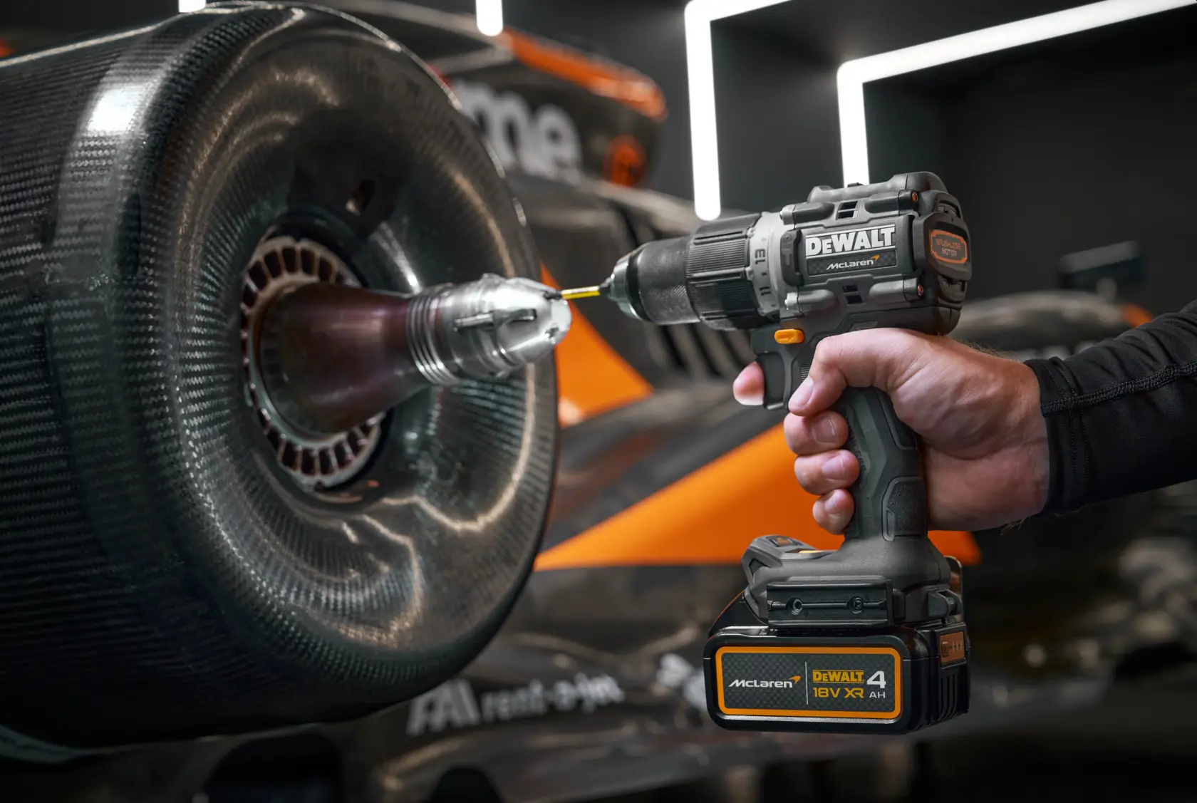 DEWALT cordless drill in use on a race car wheel, showing tool and hand close-up.