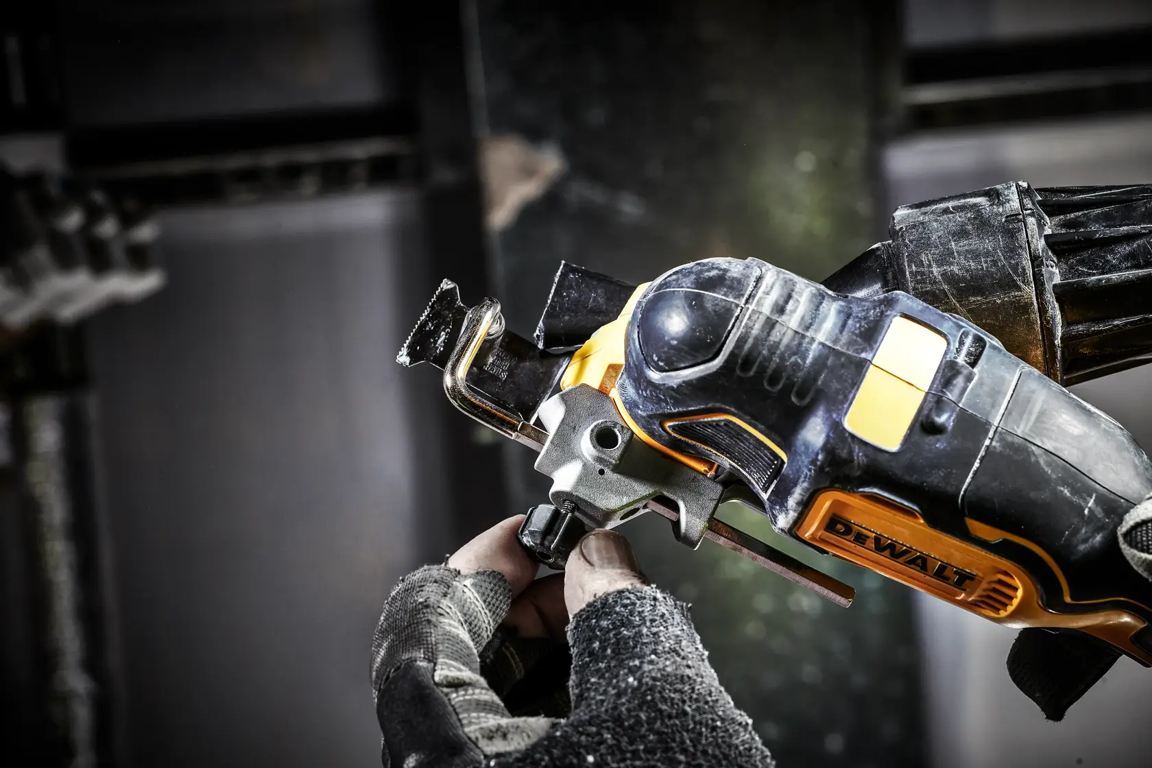 Close-up of a DEWALT DCS356N power tool in use, held by a gloved hand during a work task.