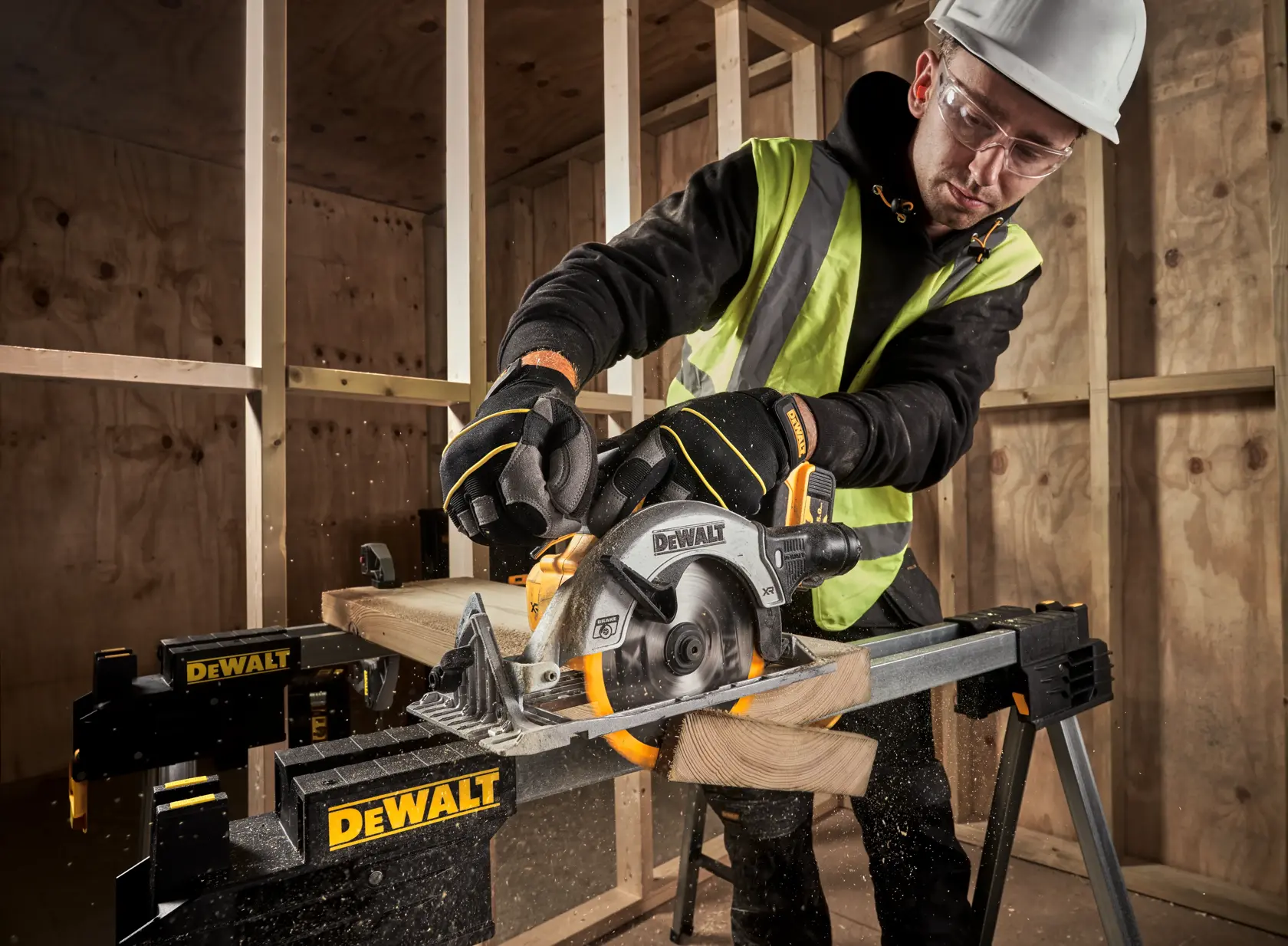 Worker uses DEWALT DCS565P2 circular saw to cut wood on a stand in a construction site.