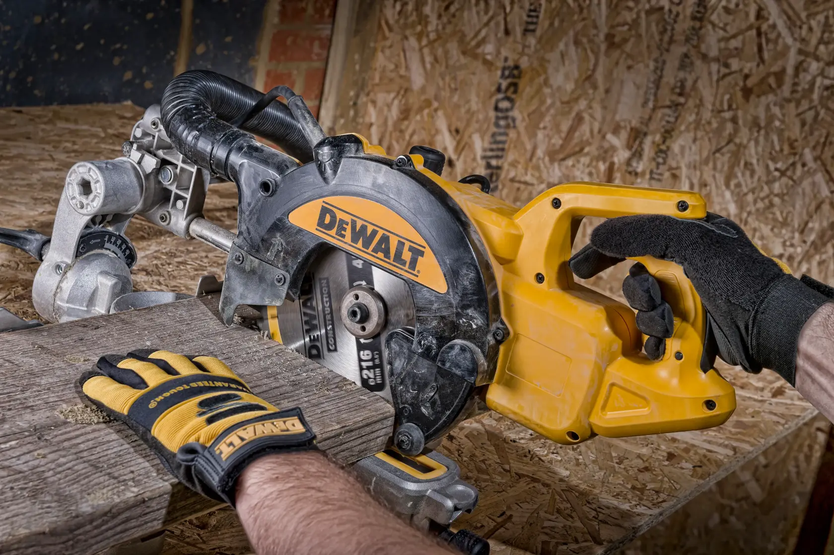 Gloved hands operate a DEWALT circular saw to cut wood on a workbench.