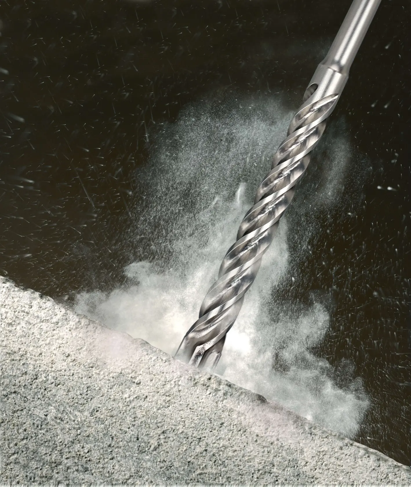 Close-up of a metallic drill bit penetrating concrete, dust and debris flying around.