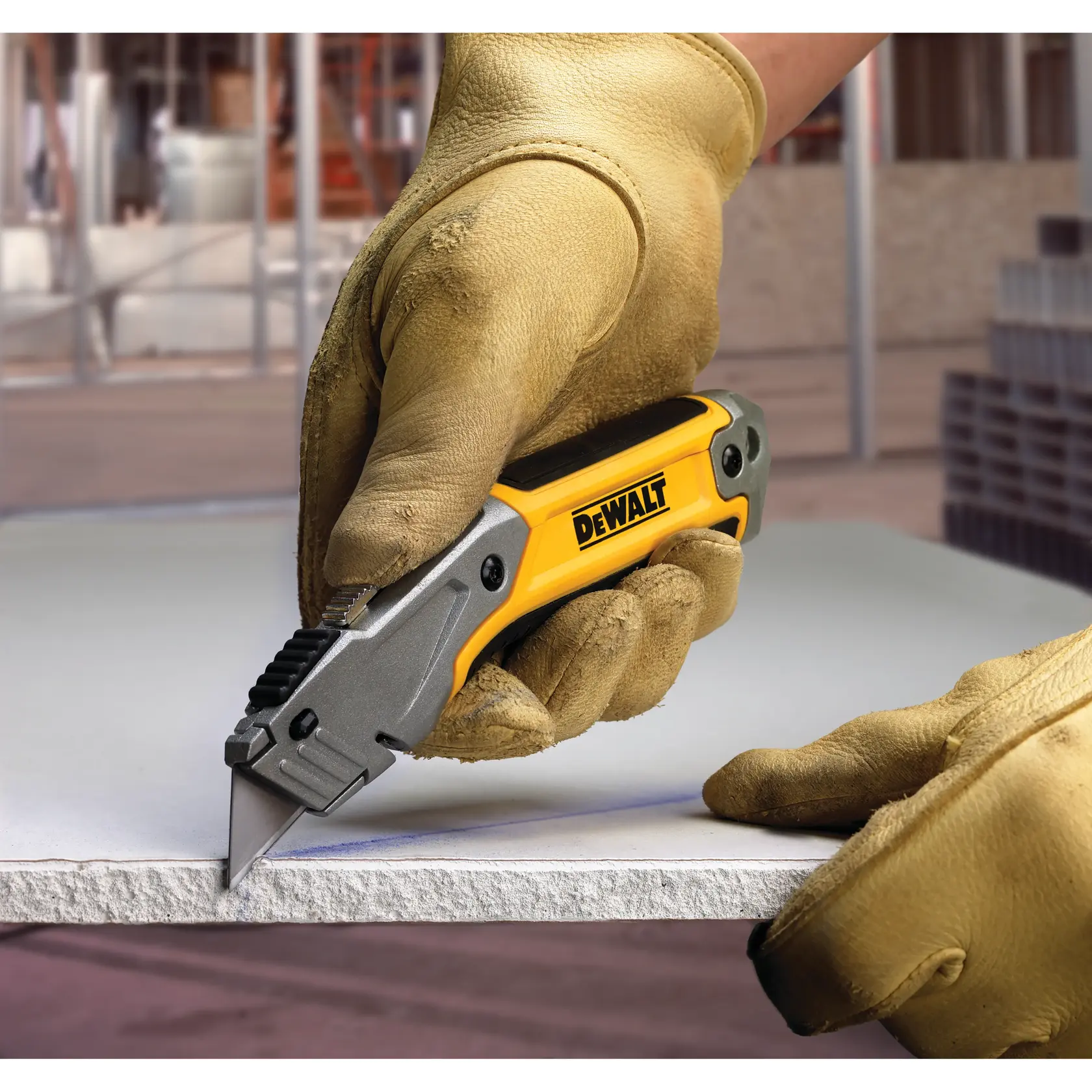 Gloved hand cutting material with a DEWALT utility knife at a construction site.